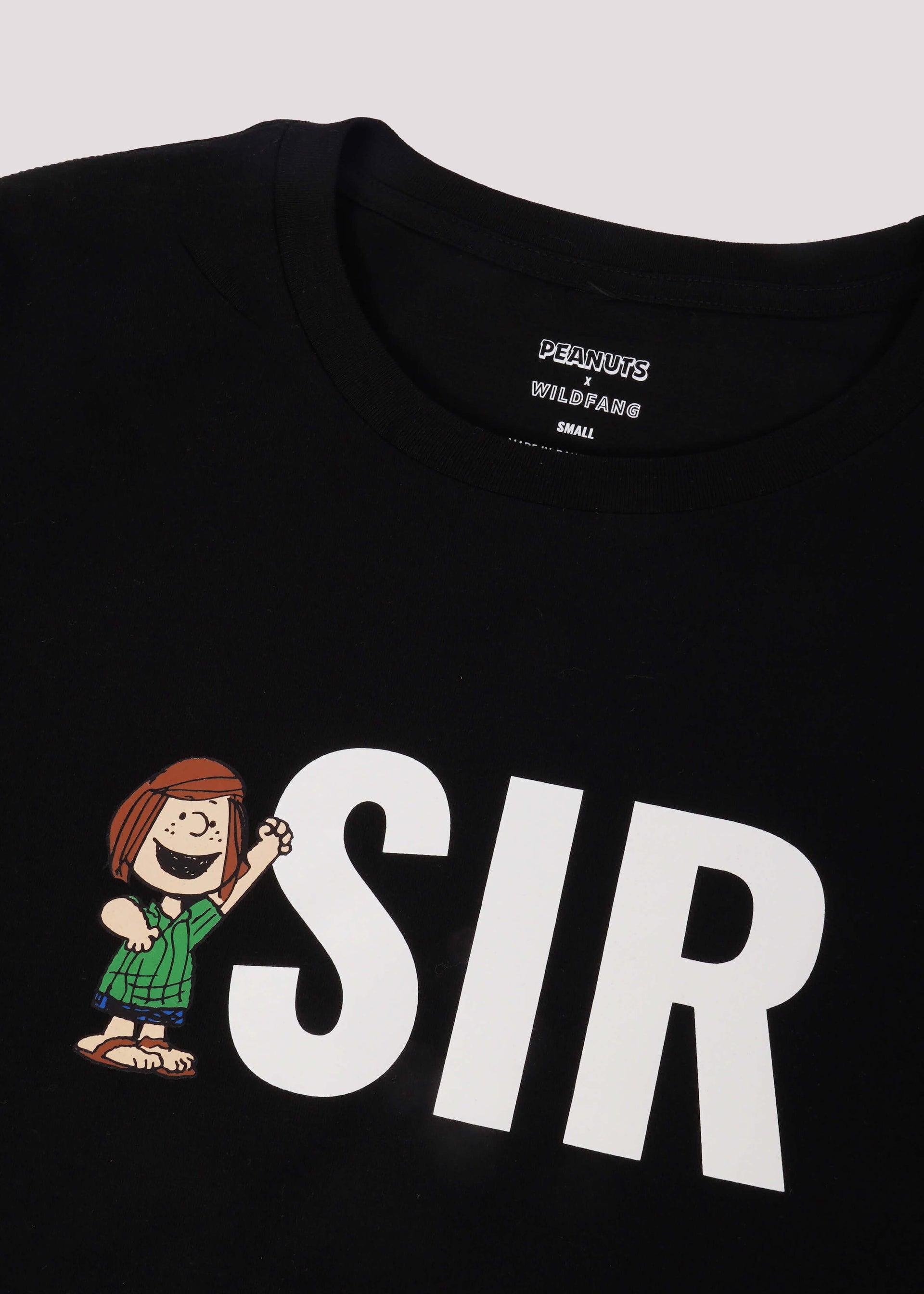 Black tshirt with "SIR" and Peppermint Patty printed on it lays flat on white background.