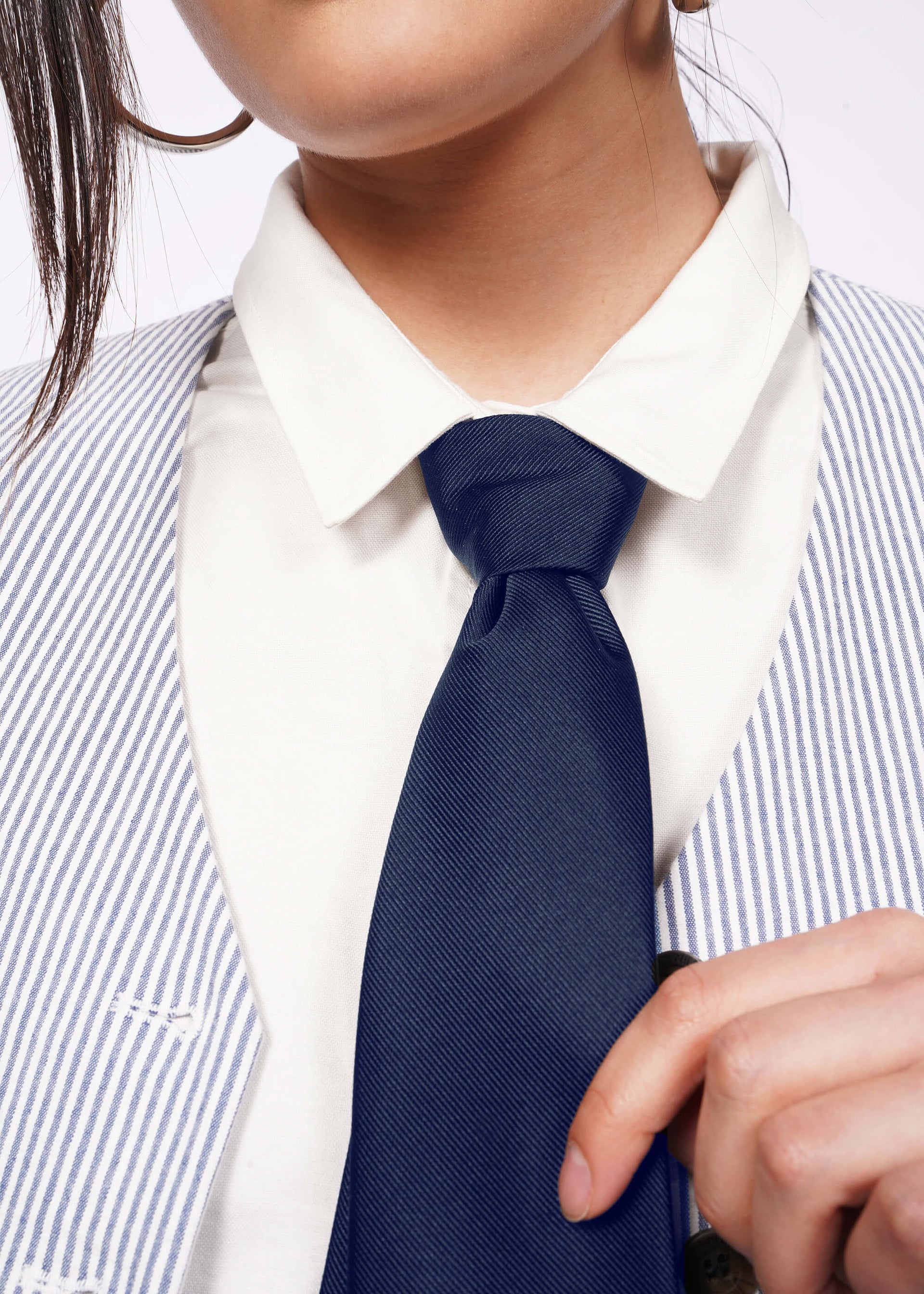 Close up of model wearing tie at neck area showing tie knot and fabric texture.